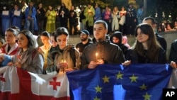 Demonstrators with Georgian and EU flags holding candles stand in front of the Kashveti Church of St. George during an opposition protest against "the Russian law" in the center of Tbilisi on May 3.