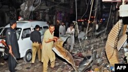 Would-be rescuers and police at the scene of the twin bombings that killed dozens at a crowded market in Peshawar on June 11 and 12