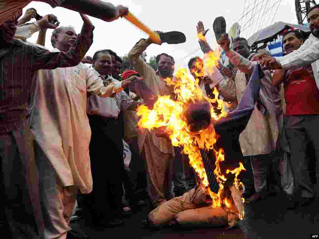 Pakistani Christians beat a burning effigy of Dove World Outreach Center Pastor Terry Jones during a protest in Lahore on September 9, held to denounce Jones' plans, since suspended, to burn copies of the Koran. Photo by Arif Ali for AFP