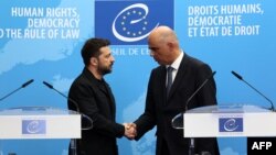 Ukrajinski predsednik Volodimir Zelenski i generalni sekretar Saveta Evrope Alen Berse rukuju se nakon potpisivanja sporazuma o osnivanju specijalnog tribunala za suđenje visokim zvaničnicima odgovornim za rusku invaziju na Ukrajinu, 25. juni 2025.