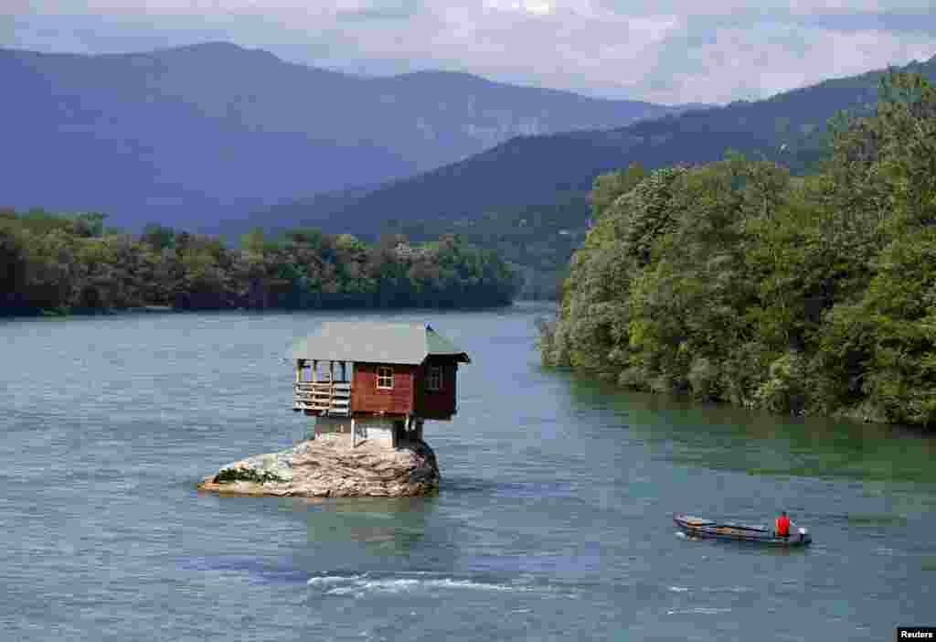 A man on a boat passes a house built on a rock on the Drina River near the western Serbian town of Bajina Basta. The house was built in 1968 by a group of young men who decided that the rock was an ideal place for a tiny shelter. (Reuters/Marko Djurica)