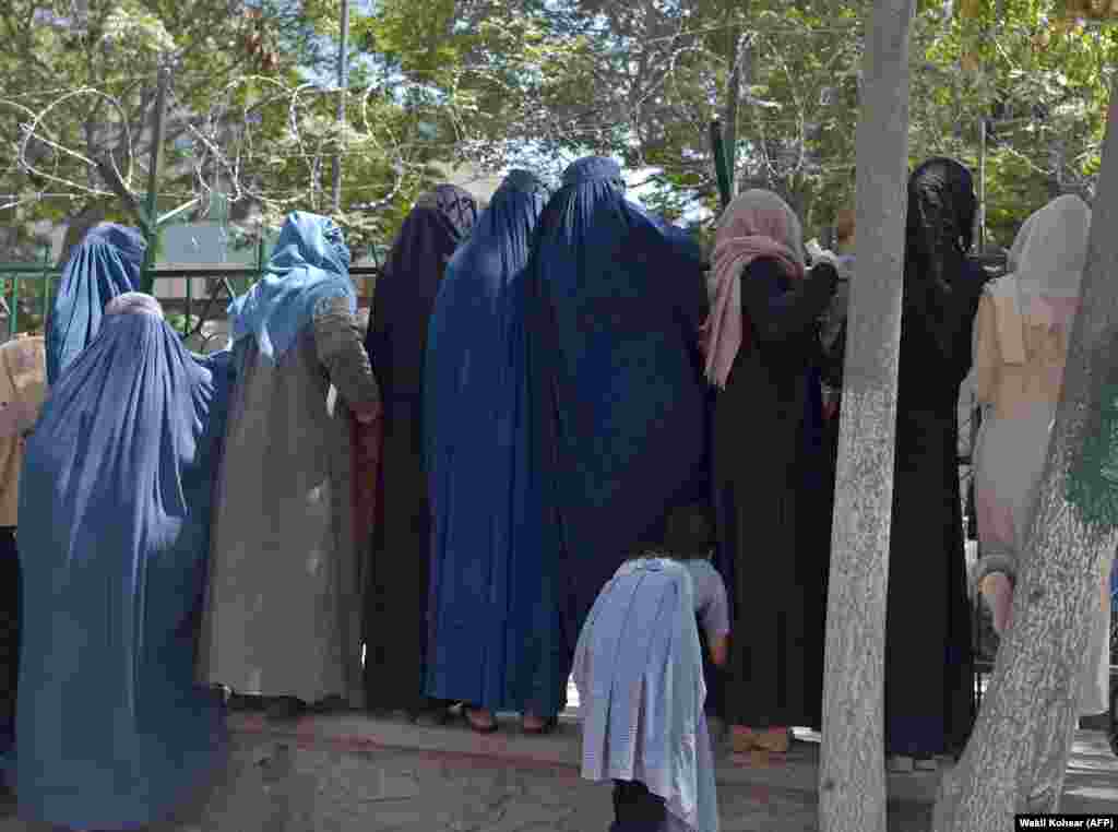Кабулдагы паркта жардам алуу үчүн кезек күтүп турган паранжачан аялдар. Бул сүрөт талибдер Кабулду басып алардан үч күн мурун тартылган.&nbsp;Бул аялдар &quot;Талибан&quot; кыймылы күчөй баштаганда Ооганстандын түндүгүнөн борбор калаа Кабулду көздөй качып келишкен.&nbsp;