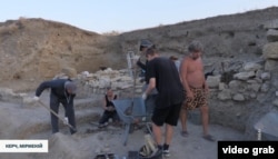 Александр Бутягин (крайний справа) на раскопках древнего городища Мирмекий. Скриншот из видео