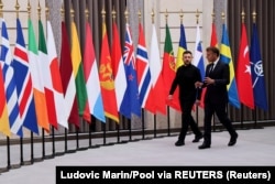 Президент Франції Емманюель Макрон та президент України Володимир Зеленський йдуть разом повз прапори, щоб очолити саміт «Коаліції охочих» в Єлисейському палаці в Парижі, Франція, 4 вересня 2025 року.