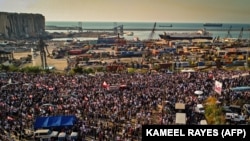 Această fotografie din 4 august 2021, surprinde masa de demonstranți, adunată în fața portului din Beirut pentru a comemora un an de la explozia care a devastat portul și orașul.