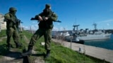 Russian soldiers guard a pier where two Ukrainian naval vessels are moored in Sevastopol, on the Crimean Peninsula, on March 5, 2014.