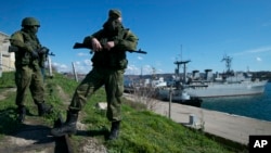 Russian soldiers guard a pier where two Ukrainian naval vessels are moored in Sevastopol, on the Crimean Peninsula, on March 5, 2014.
