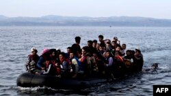 Мигранты и беженцы в надувной лодке у берегов греческого острова Лесбос, 9 сентября 2015 года.