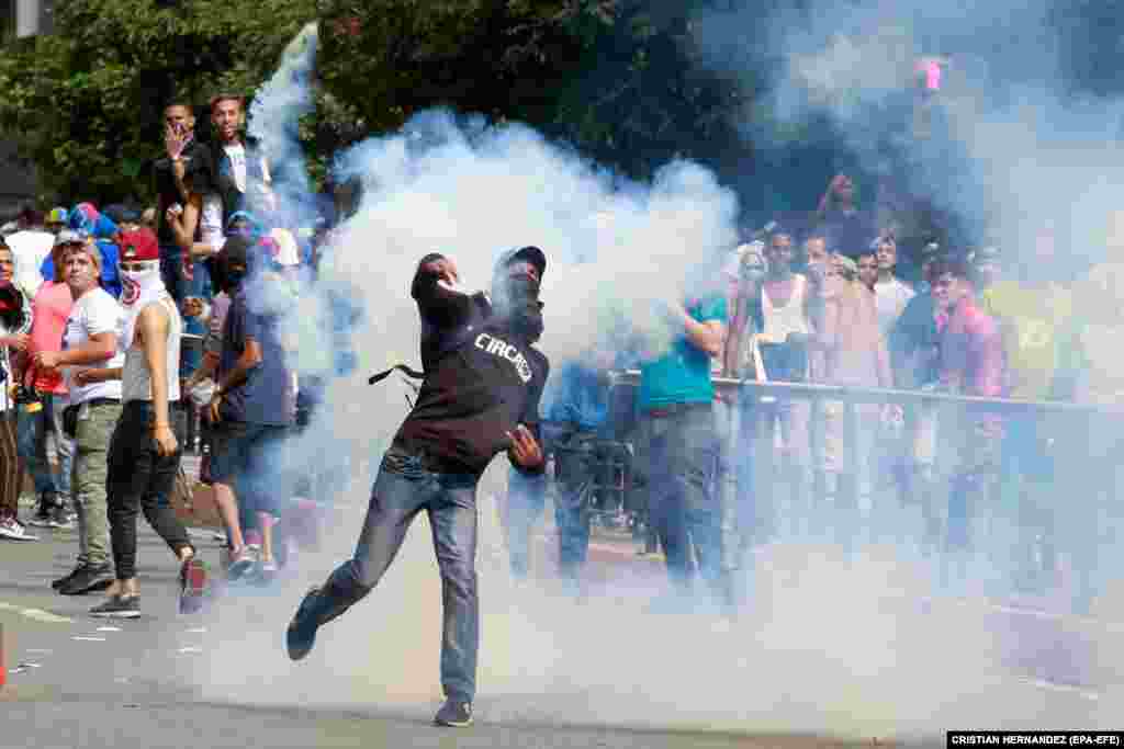 Protesters face off with police in Caracas.&nbsp;At least four people were reported to have died in overnight clashes before the nationwide protests.&nbsp;