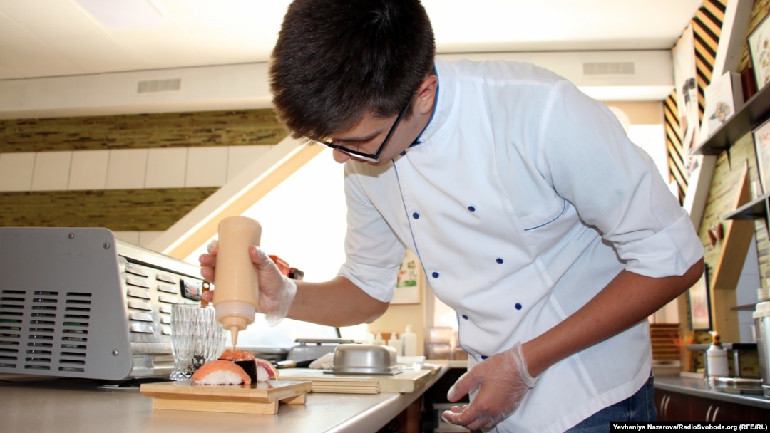 Un tânăr prepară sushi, mâncare la modă în rândul tinerilor. Imagine ilustrativă. 