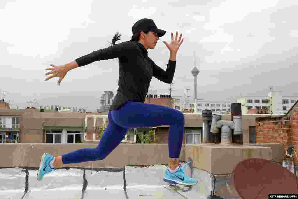Iranian athlete Maryam Toosi practices on the rooftop of her apartment building following the closure of sports facilities as part of measures aimed at containing the coronavirus in Tehran. (AFP/Atta Kenare)