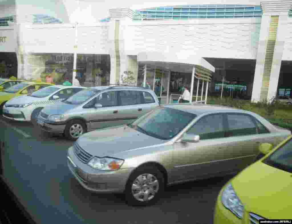 Aşgabadyň aeroportunyň duralgasynda ýolagçylara garaşyp duran ulaglar.