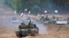 Военни машини и танкове на Полша, Италия, Канада и САЩ по време на военните учения на НАТО "Namejs 2021" на полигона в Кадага, Латвия през 2021 г.