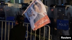 Policajci i demonstrant na protestima protiv pritvaranja gradonačelnika Istanbula Ekrema Imamolu, pored Palate pravde u Istanbulu, 22. marta 2025.