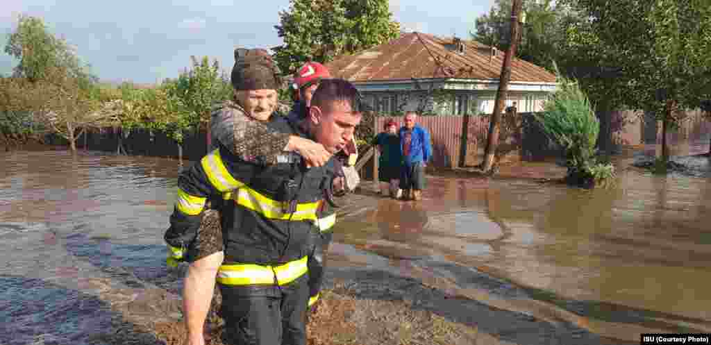  O vârstnică este cărată în spate de un pompier. Localitatea Cudalbi/jud. Galați. &nbsp; 