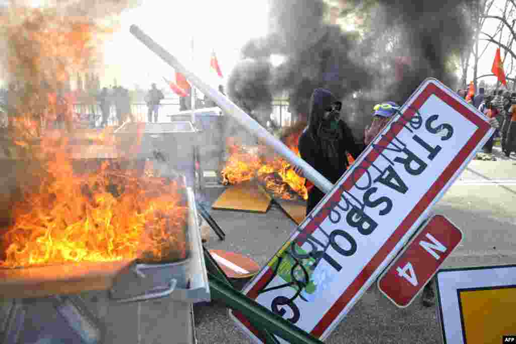 Запалени барикади на анти НАТО демонстрациите во Стразбур - FRANCE, Strasbourg : Anti-Nato protesters set fire to a barricade on the Europe Bridge in Strasbourg, eastern France, on April 4, 2009, to protest against the NATO summit. Small mobile groups of protestors played cat and mouse with battalions of French riot police, seeking to cause maximum disruption on the final day of the NATO summit in Strasbourg. AFP PHOTO DDP/AXEL SCHMIDT