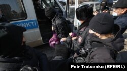 Полицейские задерживают женщину во время митинга в Алматы, 28 февраля 2021