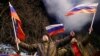 Pro-Russia activists in Donetsk react on the street as fireworks explode in the sky after Russian President Vladimir Putin signed a decree recognizing the two Russia-backed separatist regions in eastern Ukraine as independent entities.