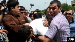 Plainclothes Azerbaijani police officers on May 23 detain the opposition activists who tried to hold a rally near the public television station that is showing the Eurovision broadcasts in Baku.