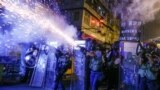 Полиция кызматкерлери нааразылык акциясына чыккандарга карата көздөн жаш агыза турган газ жана желим окторду пайдаланууда. Гонконг. 14-август, 2019-жыл.<br />
Кытайдын курамына кирген бул автономиялык аймакта массалык нааразылык акциялары 2019-жылдын жай айларында башталган. Бийликтин кылмышка шектүү адамдарды Кытайга экстрадициялоо тууралуу мыйзамды кабыл алуу планы калың элди нааразы кылган.&nbsp;<br />
<br />
&nbsp;