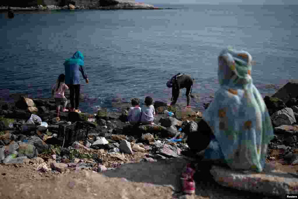 Migrantët duke u freskuar në një plazh në ishullin Lesbos.&nbsp;