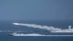 IRAN -- Iranian military fires a missile targeting a mock-up of U.S. aircraft carrier in the strategic Strait of Hormuz, July 28, 2020