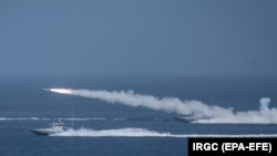 IRAN -- Iranian military fires a missile targeting a mock-up of U.S. aircraft carrier in the strategic Strait of Hormuz, July 28, 2020