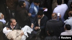 An elderly man is carried by a volunteer after casting his vote at a polling station during parliamentary elections in Cairo on November 28.