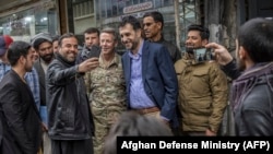 FILE: Men take 'selfie' with their smartphones to pose with Commander of U.S. and NATO forces in Afghanistan General Austin Scott Miller (C-L), and with Afghan Acting Defense Minister Asadullah Khalid (C-R), in Kabul in Februray.