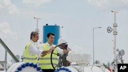 Kiriákosz Micotákisz görög miniszterelnök (balra) és bolgár kollégája, Kiril Petkov megnyitja a gázcsapot az új gázvezeték átadásán a görögországi Komotiniben 2022. július 8-án