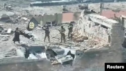 A still image taken from video released by the press service of Wagner head Yevgeny Prigozhin claims to shows Wagner fighters waving a flag atop a building in Bakhmut, Ukraine, on March 2.