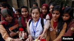 Students light candles as they gather to pray and pay tribute to the victims of the Taliban attack on the Army Public School in Peshawar, Pakistan.