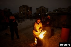 Жителі Києва гріються біля вогнища у дворі під час блекауту, січень 2026 року