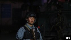 An Afghan security official secures the scene of a gunfight between militants and Government forces near a guest house in Kabul on 13 May.