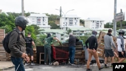 Маскирани жители на Нова Каледония блокират път, за да насочат активисти, подкрепящи независимостта, в определена посока, 15 май 2024 г.