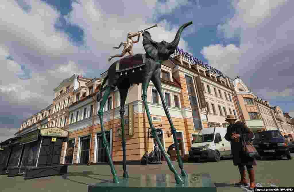 A woman in Minsk, Belarus, looks at the sculpture of an elephant designed by Salvador Dali. (epa-EFE/Tatyana Zenkovich)