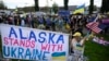 Демонстранти махають прапорами та тримають банер під час мітингу на підтримку України вздовж шосе Сьюард в Анкориджі, Аляска, 14 серпня 2025 року, напередодні запланованої зустрічі президентів США та Росії