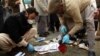 Pakistani security personnel collect evidence at the bomb blast site in Mardan on December 29. 