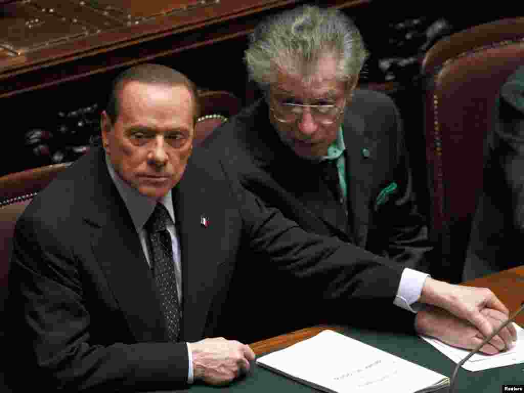 Italian Prime Minister Silvio Berlusconi (left) holds League North Party leader Umberto Bossi&#39;s hand during a finance vote. Berlusconi has pledged to stand down onced parliament passes budget reforms. (Photo for Reuters by Tony Gentile)