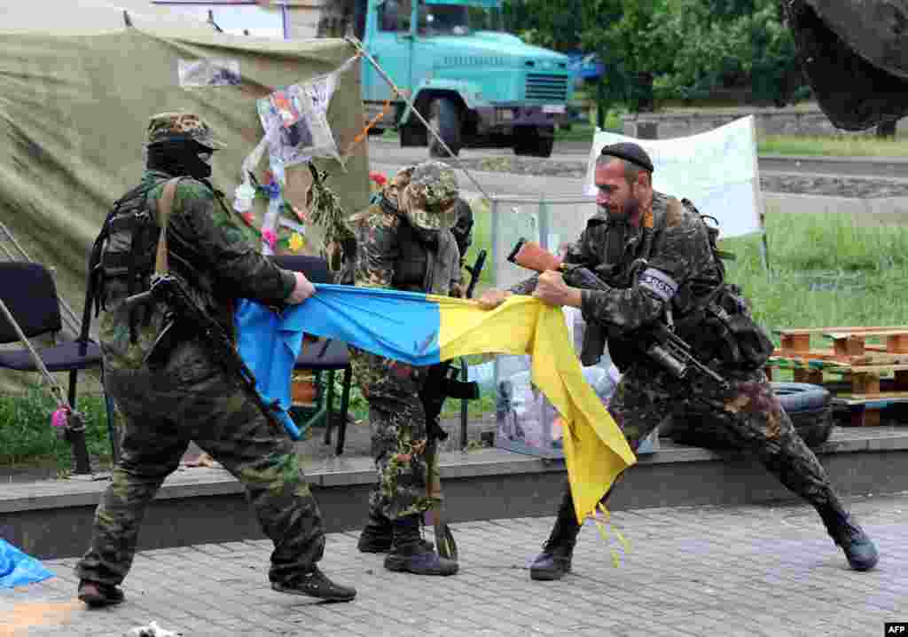 Проросійські бойовики батальйону &laquo;Схід&raquo; розривають український прапор біля будівлі ОДА у Донецьку, 29 травня 2014 року