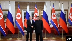 Ruski predsjednik Vladimir Putin (lijevo) i sjevernokorejski lider Kim Jong Un poziraju za fotografiju nakon zvanične ceremonije dočeka u Pjongjangu 19. juna
