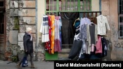 GEORGIA -- A woman walks past by a second hand shop in Tbilisi, February 16, 2018