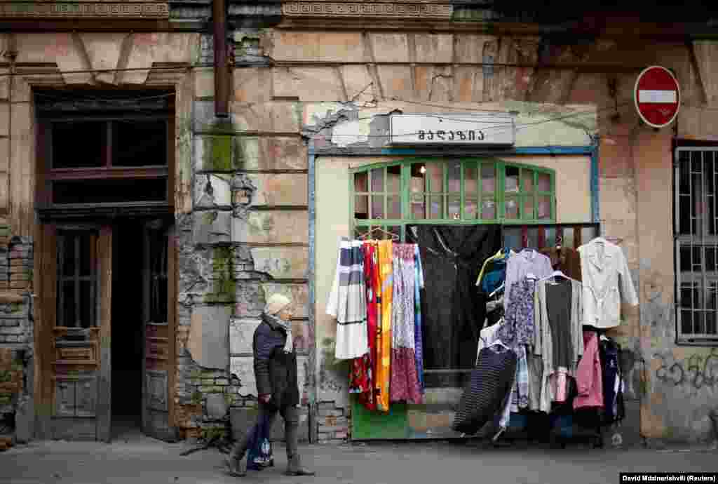 A woman walks by a second hand shop in Tbilisi, Georgia. (Reuters/David Mdzinarishvili)