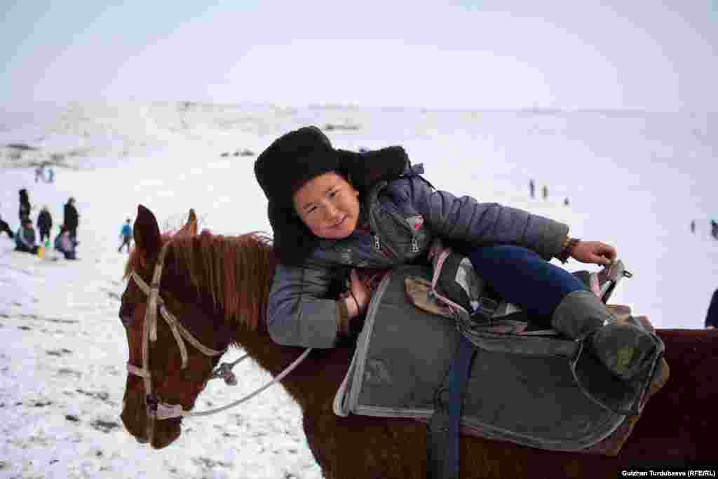 A boy climbs on a horse in Kyrgyzstan&#39;s Chui region on February 23. (Gulzhan Turdubaeva, RFE/RL)