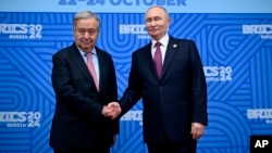 Secretarul general al ONU, Antonio Guterres, dă mâna cu președintele rus Vladimir Putin la summitul de la Kazan, 24 octombrie. 