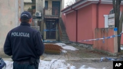 A police officer stands guard at the scene of a deadly shooting incident in Cetinje which occurred in the Montenegrin city later on January 1. 