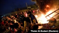 Demonstrators defy a curfew two days after the nationwide anti-government protests turned violent, in Baghdad on October 3.