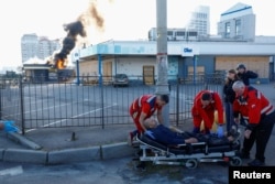 Paramedics transport an injured resident after a Russian drone strike on a gas station in Kyiv on September 15.