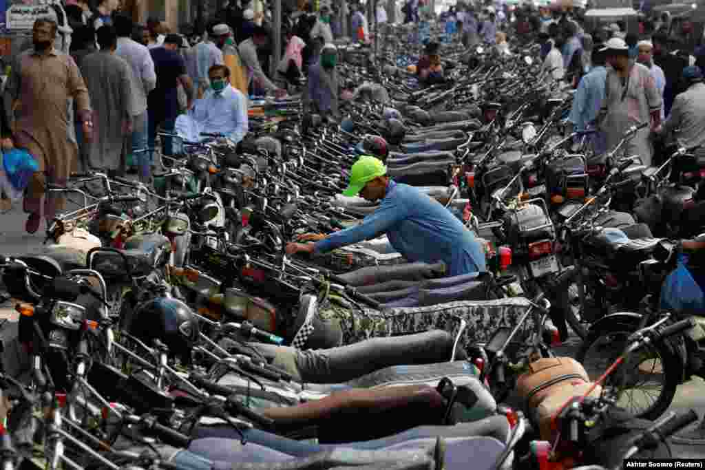 A Pakistani boy parks his motorcycle among hundreds of others outside a shopping bazaar after the easing of lockdown measures in Karachi on May 12. (Reuters/Akhtar Soomro)