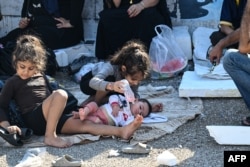 People who fled Israeli bombardment in Beirut's southern suburbs gather in the Lebanese capital's downtown district, where they spent the night.